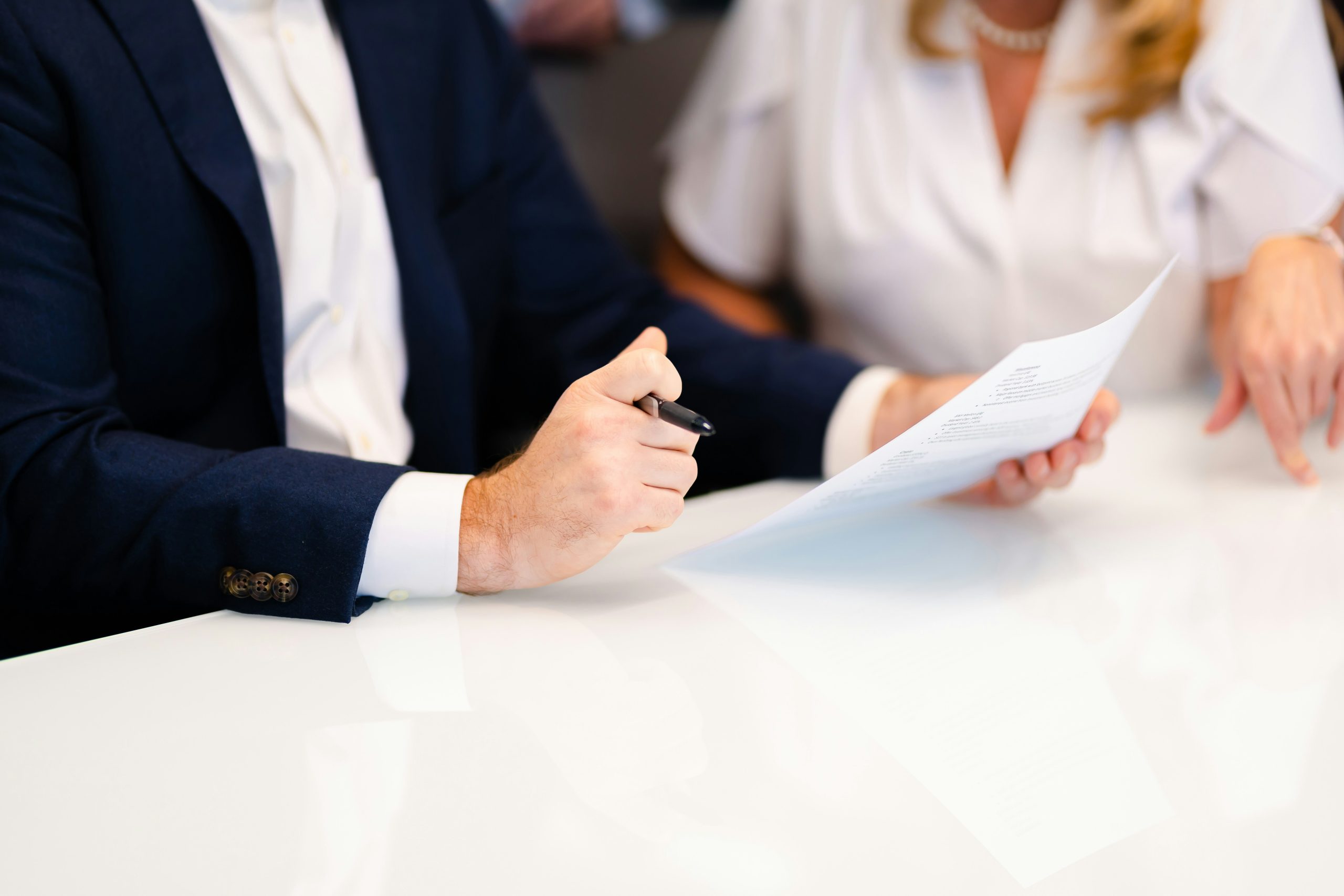 lawyer holding form and pen reviewing document with client