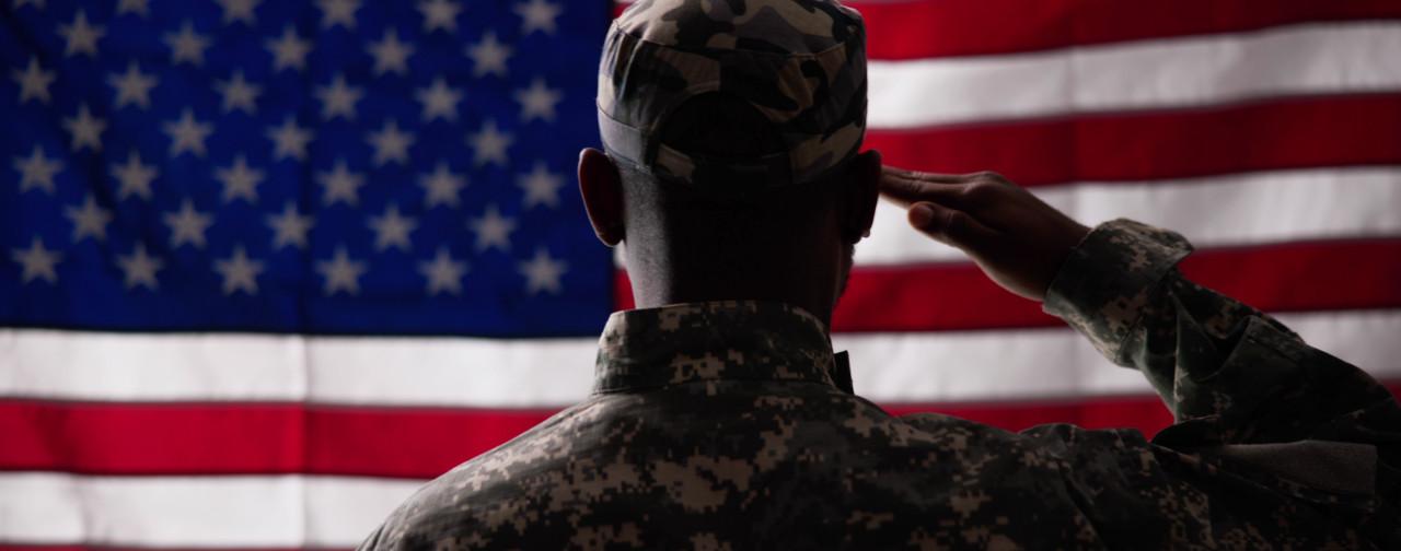 military service member saluting the American flag